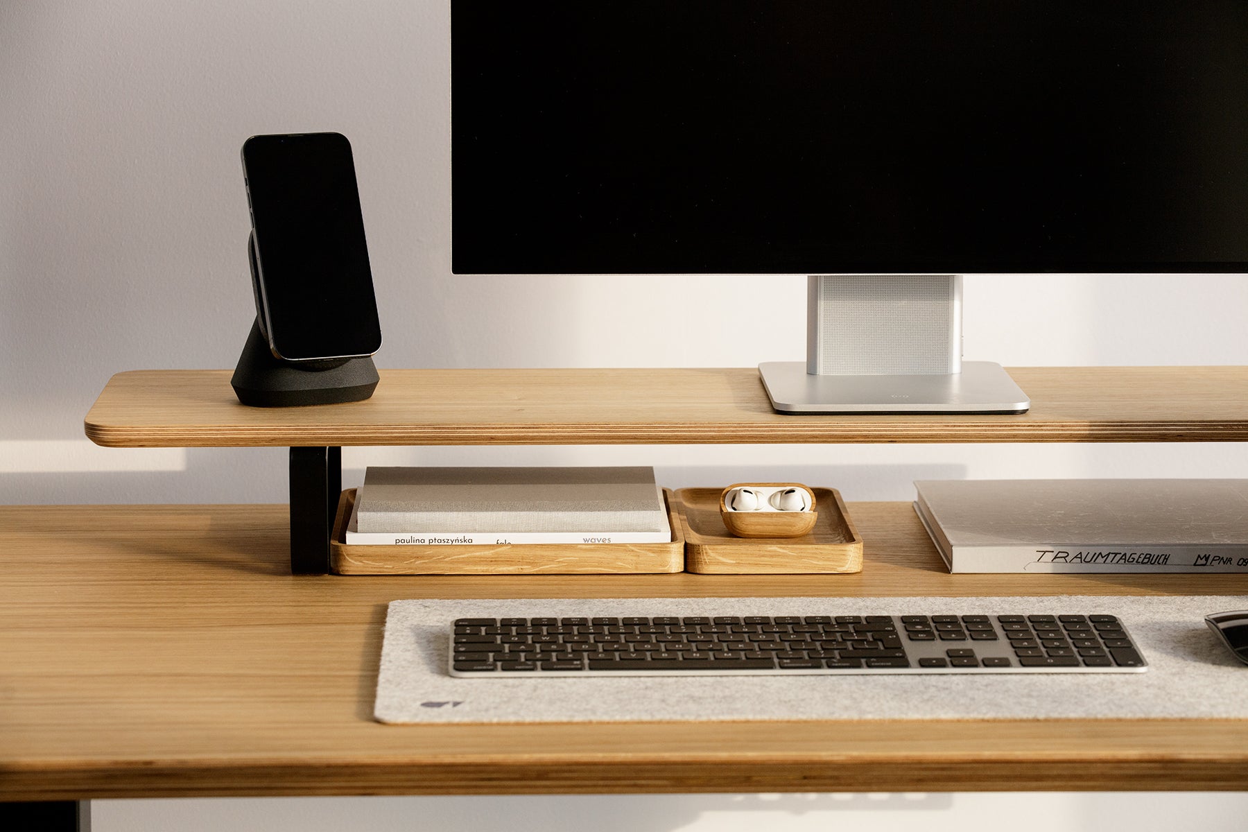 black magsafe iphone stand with iphone on a veneer desk shelf | black