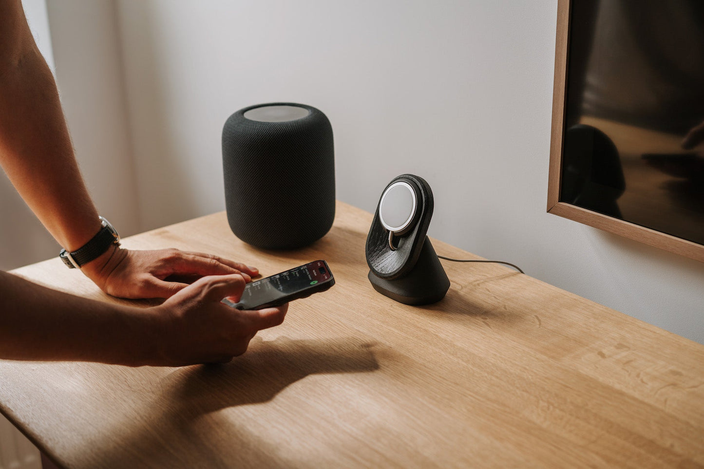 black magsafe iphone mount on a oak wooden desk with spotify music and homepod music center | -